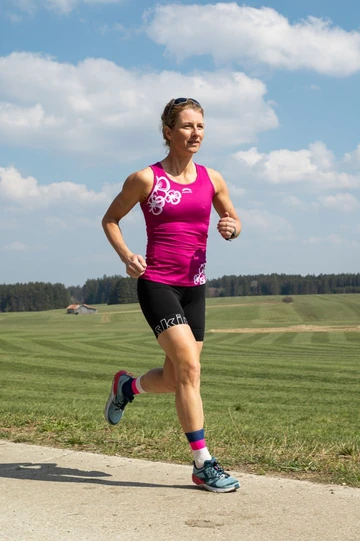 Petra Paule beim Lauftraining vor gemähten Wiesen