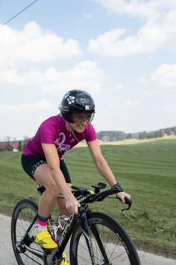 Petra Paule auf dem Zeitfahrrad auf einer Landstraße im Allgäu