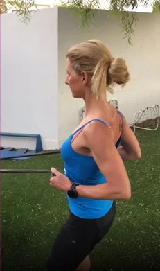 Petra Paule im Profil beim Laufen auf einer Rasenfläche, Sportuhr am Handgelenk